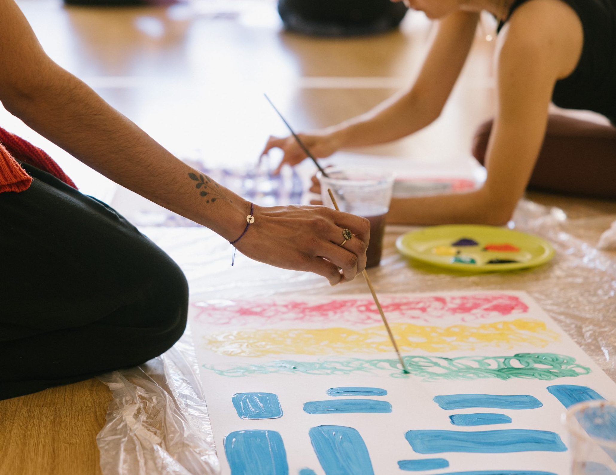 Manos de alumnas de la formación de máster en arteterapia gestalt, pintando sus polaridades.